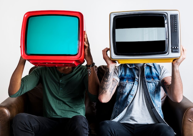 Free photo people holding retro television next to each other