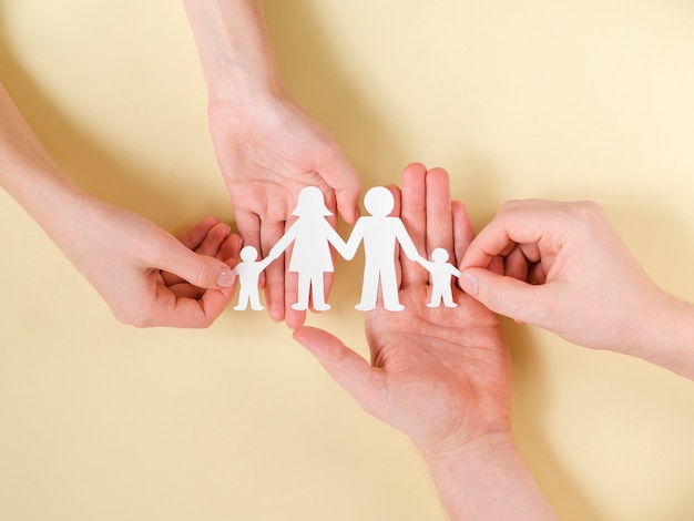 Free photo people holding together in hands cute paper family