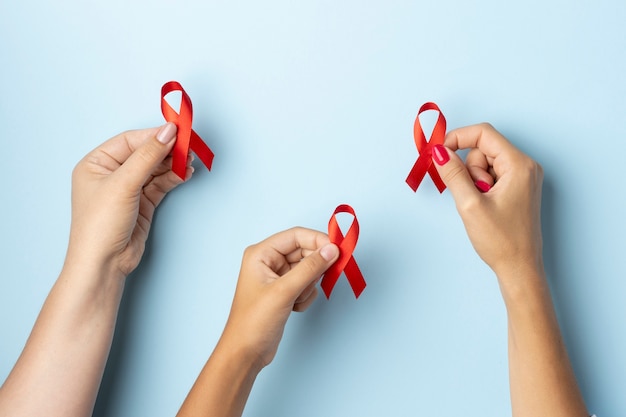 People holding an world aids day red symbol