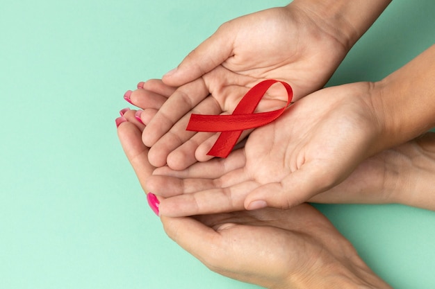 People holding an world aids day red symbol