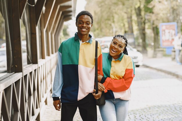 People in identifical clothes. African couple in autumn city.
