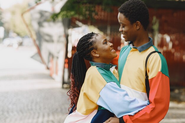 People in identifical clothes. African couple in autumn city.