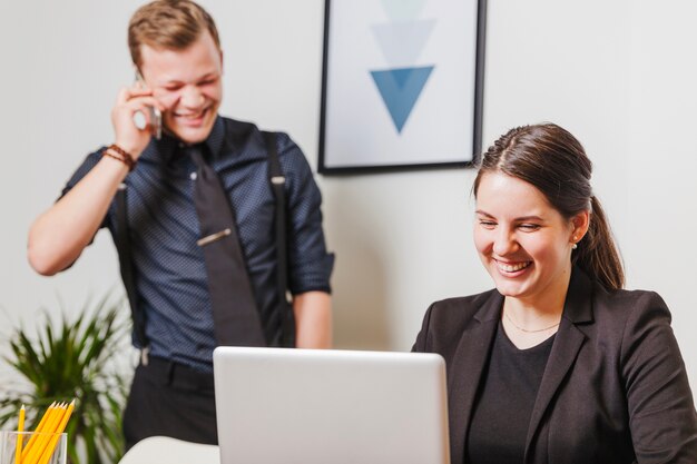 People laughing and working in office