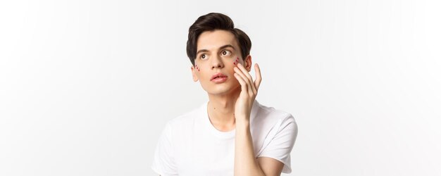 People lgbtq community and lifestyle concept beautiful young gay man applying glitter under eyes for