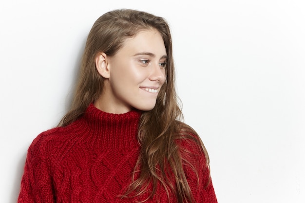 사람, 라이프 스타일 및 아늑함 개념. 추운 겨울 날에 따뜻한 니트 스웨터를 입고 집에서 시간을 보내는 매력적인 매력적인 젊은 여성