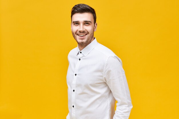 People, lifestyle, success and confidence concept.  cheerful attractive young Caucasian male wearing formal stylish clothes posing isolated with confident broad smile