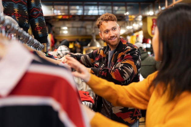 People looking at clothes in thrift shop side view