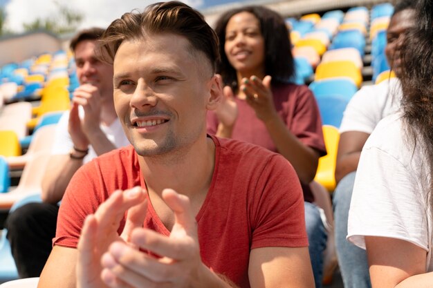 People looking together at a football game in a sunny day