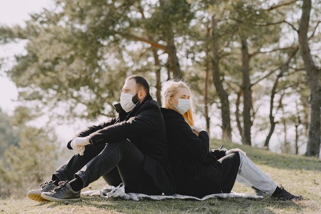 People in masks sitting in a forest