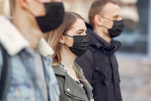 People in a masks stands on the street