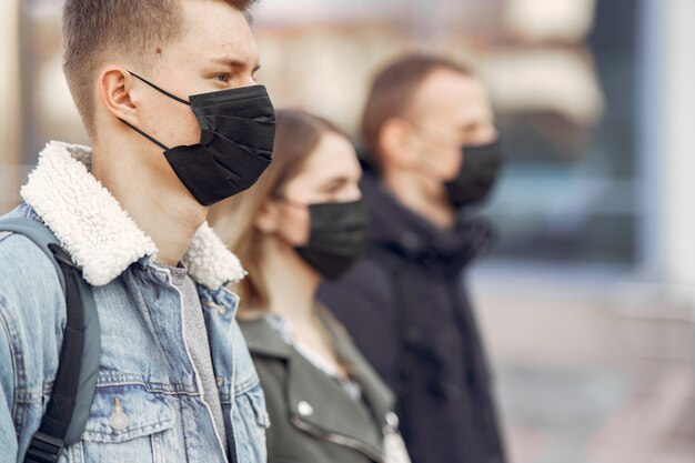 People in a masks stands on the street