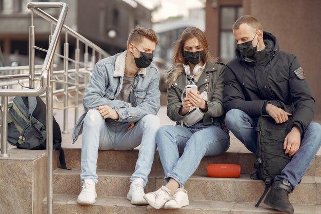 People in a masks stands on the street