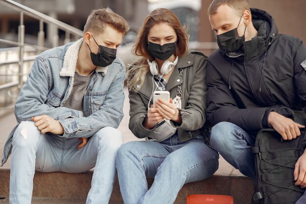 People in a masks stands on the street