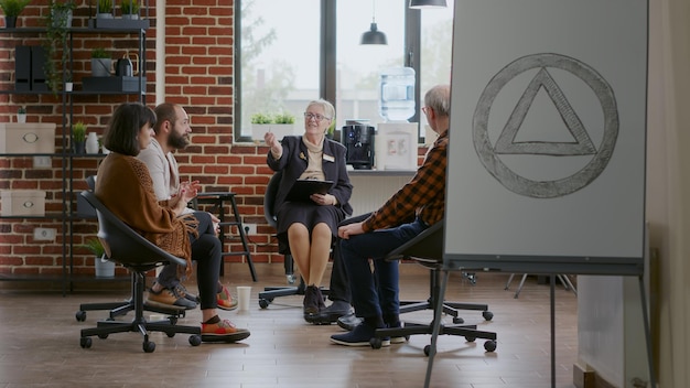 Free photo people meeting psychiatrist to discuss recovery at aa group therapy session. patients sitting in circle and having conversation about addiction with therapist at rehabilitation program.