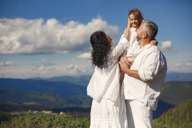 People in a mountain. Grandparents with grandchildren. Woman in a white dress.