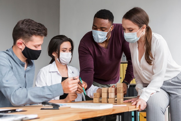 Foto gratuita persone in ufficio durante una pandemia che hanno una riunione con le maschere