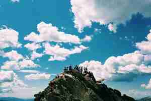 무료 사진 푸른 하늘 위로 산의 정상에있는 사람들