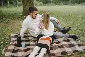 Free photo people in a park. woman in a brown coat. man in a white sweater. couple in a picnic.