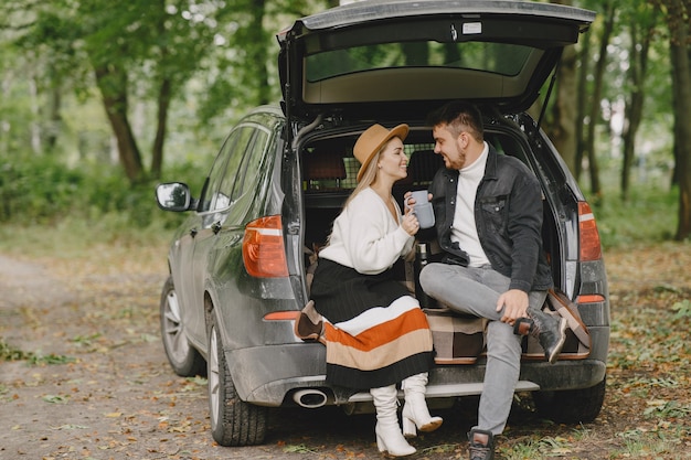 People in a park. Woman in a white sweater. People in a car trunk.