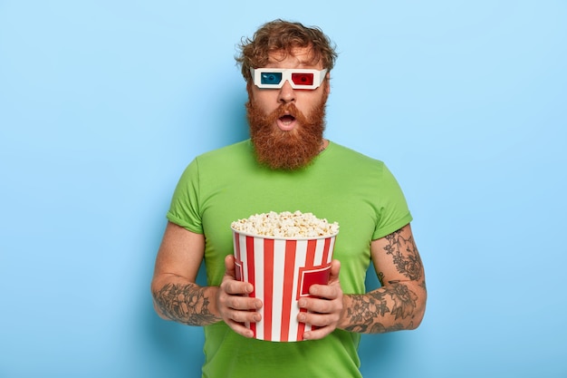 People and pastime concept. Scared bearded ginger man watches film which get his reaction