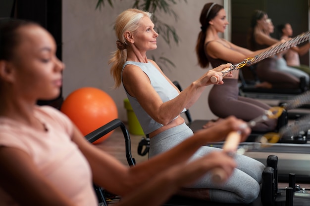 People in pilates reformer class exercising their bodies