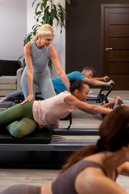 People in pilates reformer class exercising their bodies