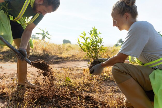 People planting tree on the countryside