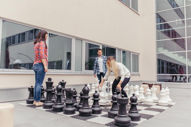 Free photo people playing oversized chess outdoors