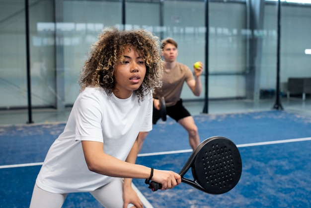 People playing paddle tennis inside