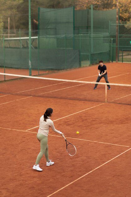 People playing tennis game in winter time