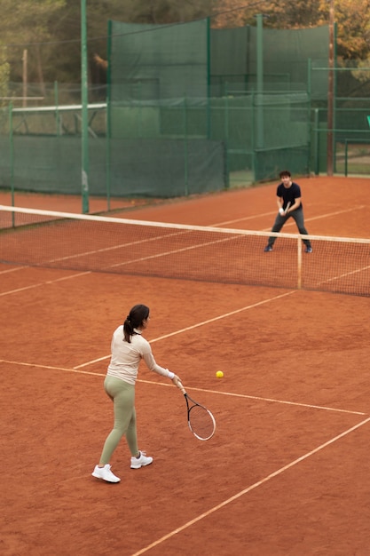 People playing tennis game in winter time