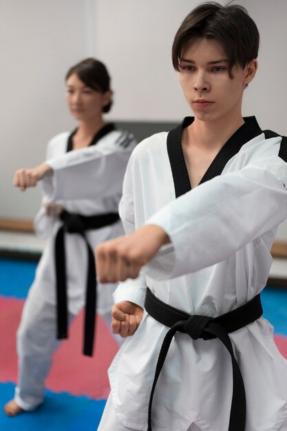 People practicing taekwondo in a gymnasium