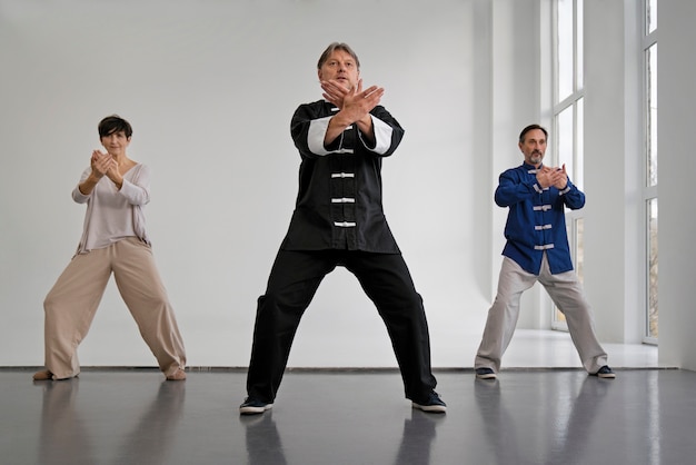 Foto gratuita persone che praticano la vista frontale del tai chi