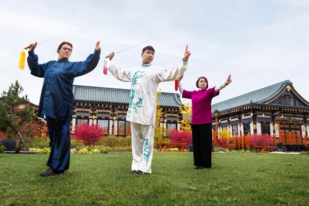 people practicing tai chi outdoors full shot