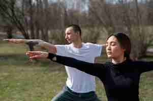 Foto gratuita persone che praticano yoga all'esterno