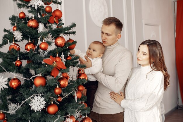 クリスマスの準備をしている人。クリスマスツリーのそばの人々。家族はお祭りの部屋で休んでいます。