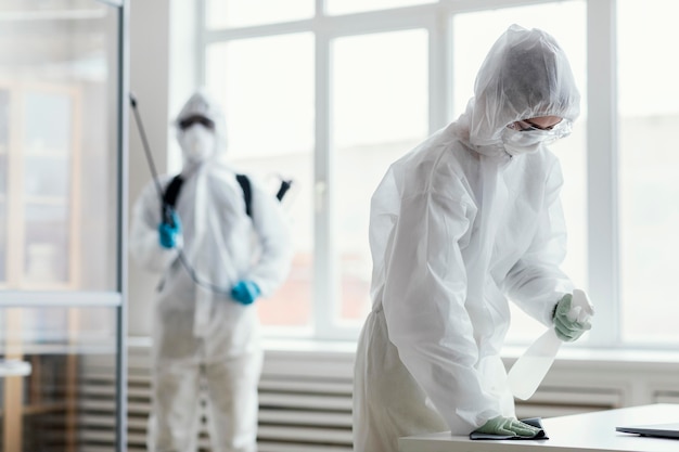 People in protective equipment disinfecting
