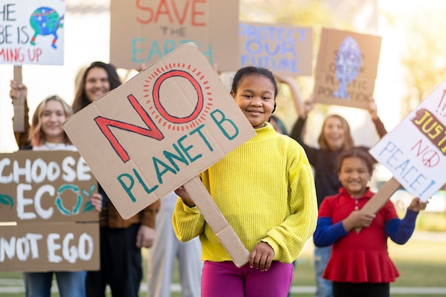 Люди протестуют с плакатами на открытом воздухе во Всемирный день окружающей среды