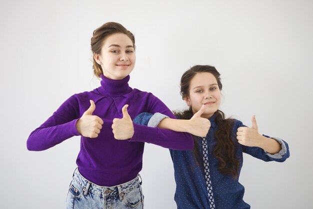 People, relationships, family and body language. Picture of emotional young woman and her teenage sister standing next to each other