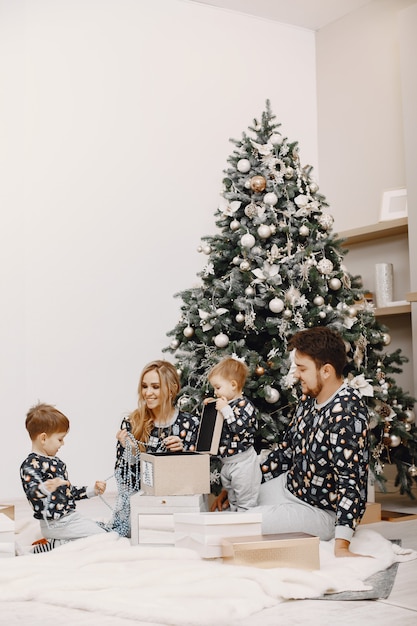 People repairing for Christmas. People playing with child. Family is resting in a festive room.