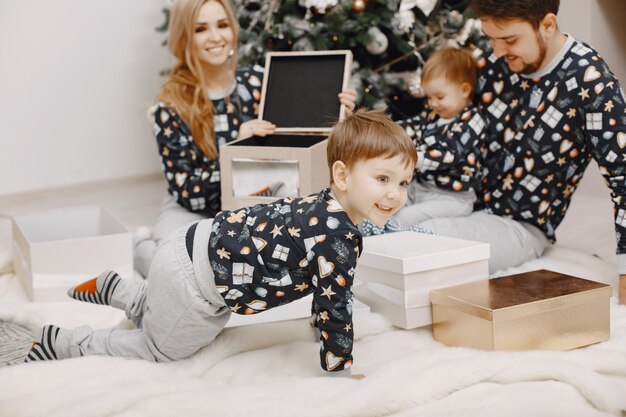 People repairing for Christmas. People playing with child. Family is resting in a festive room.