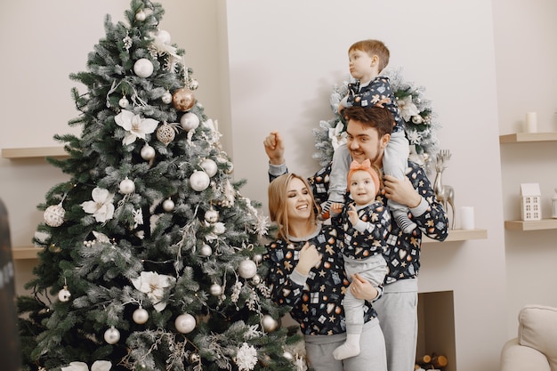 People repairing for Christmas. People playing with child. Family is resting in a festive room.