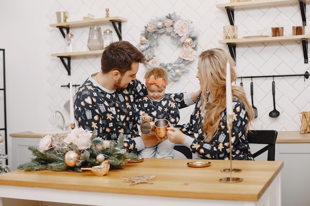 Persone che riparano per natale. persone che giocano con la figlia. la famiglia sta riposando in una cucina festiva.