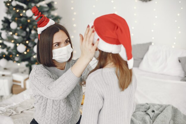 People reparing for Christmas. Coronavirus theme. Mother playing with her daughter. Child in a gray sweater.