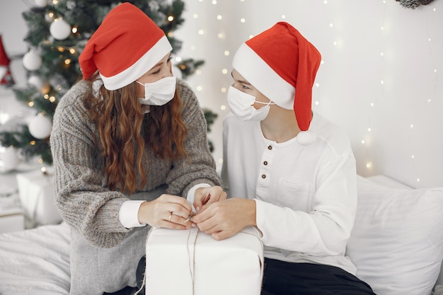 People reparing for Christmas. Coronavirus theme. Mother playing with her son. Boy in a white sweater.