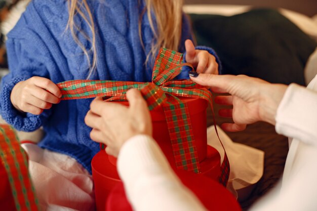 Люди делают ремонт к Рождеству. Мать играет со своей дочерью. Семья отдыхает в праздничном зале. Ребенок в синем свитере.