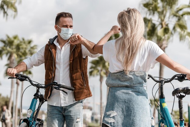 People riding a bike while wearing a medical mask