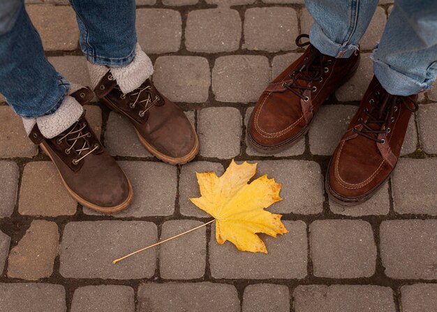 People's shoes around yellow leaf