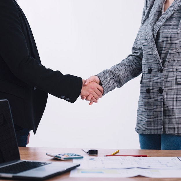 People shaking hands near table