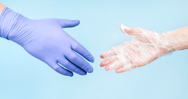 People shaking hands with gloves